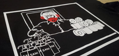 Black t-shirt with a graphic design of a person wearing headphones and holding a phone, with text and logos on a black background.